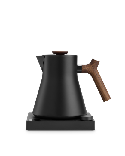 Fellow Corvo EKG Electric Kettle, matte black with wooden handle, on square base.